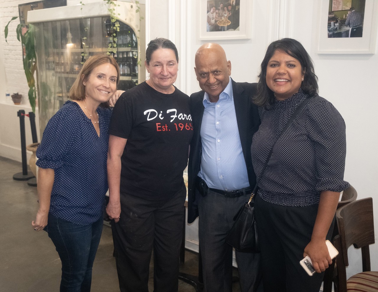 Four people smile at the camera