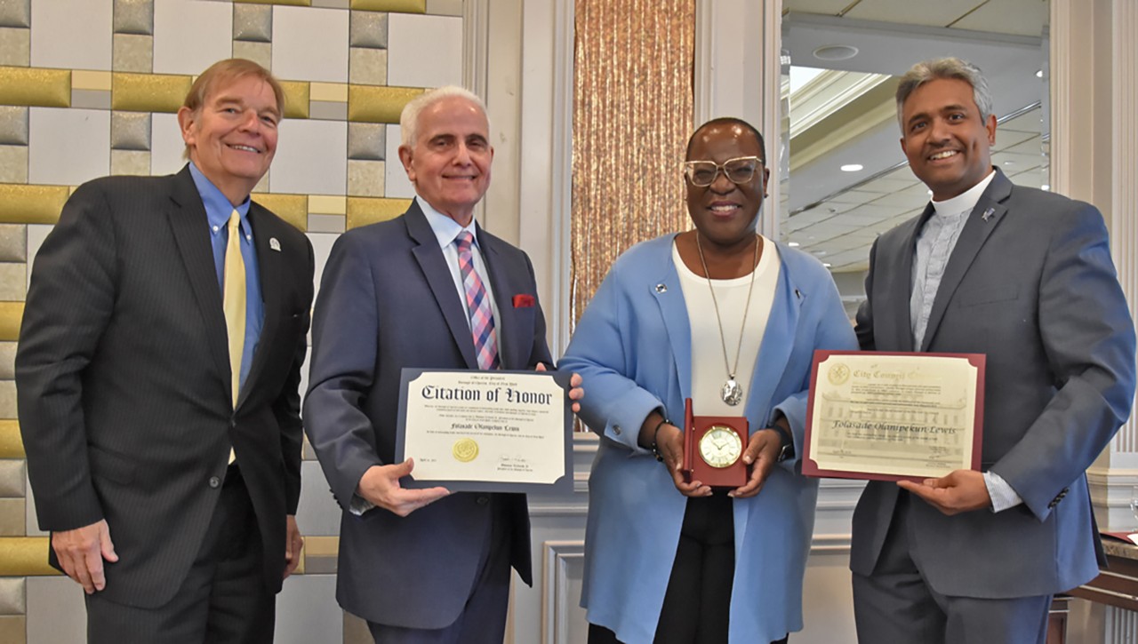 People smile and give woman an award