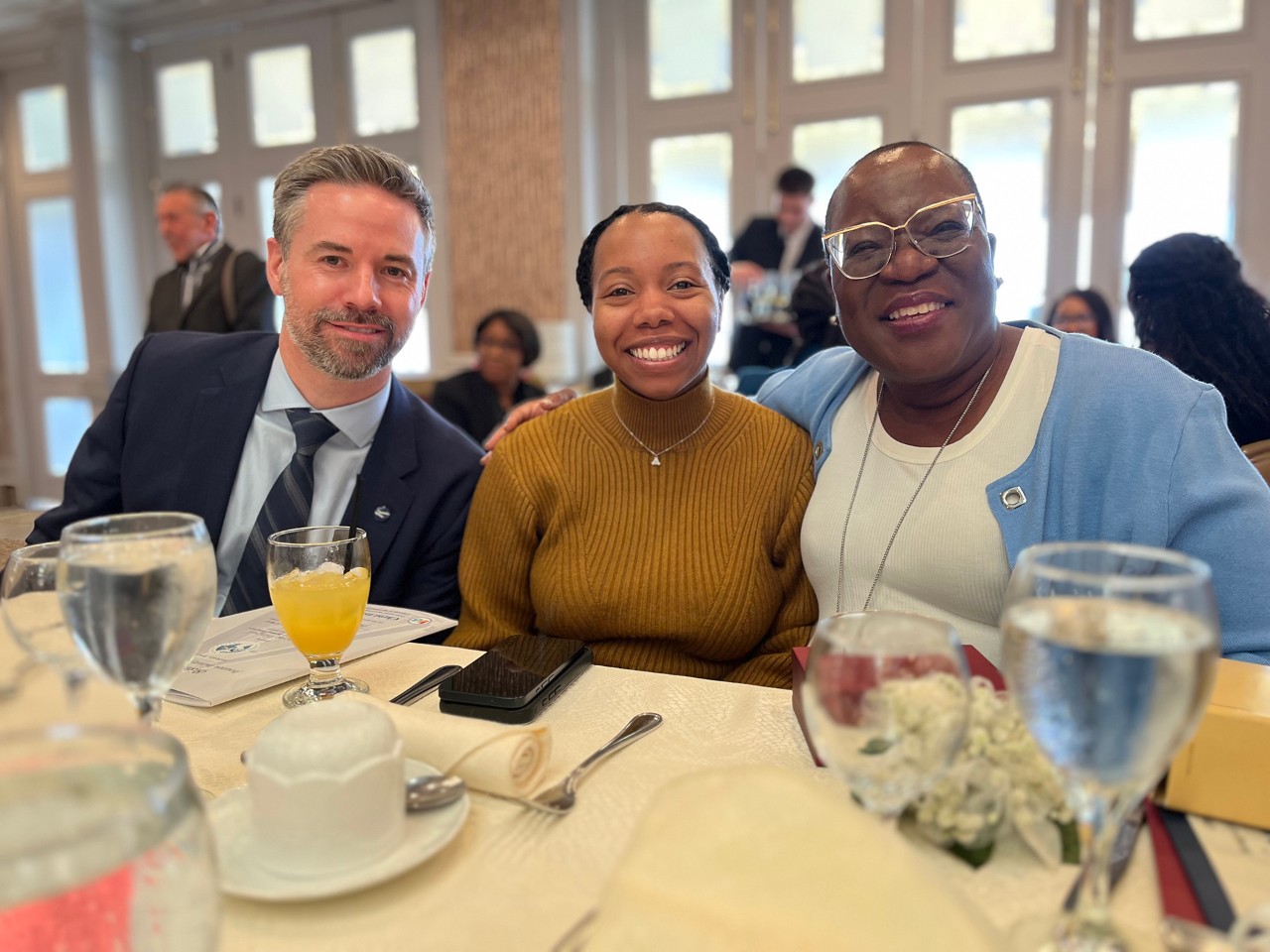 Three people smile at camera